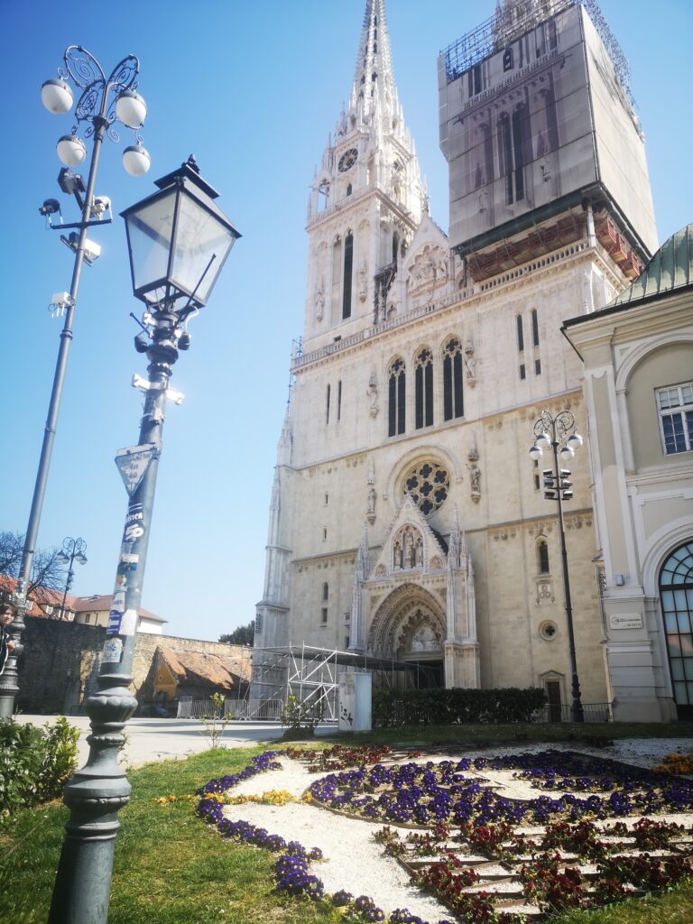 Image of the famous city landmark: Zagreb Cathedral. The right spire has scaffolding around it, as well as the entrance.