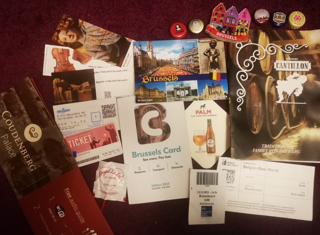 A collection of ticket stubs, leaflets, beer bottle caps, souvenirs and the Brussels Card information booklet.