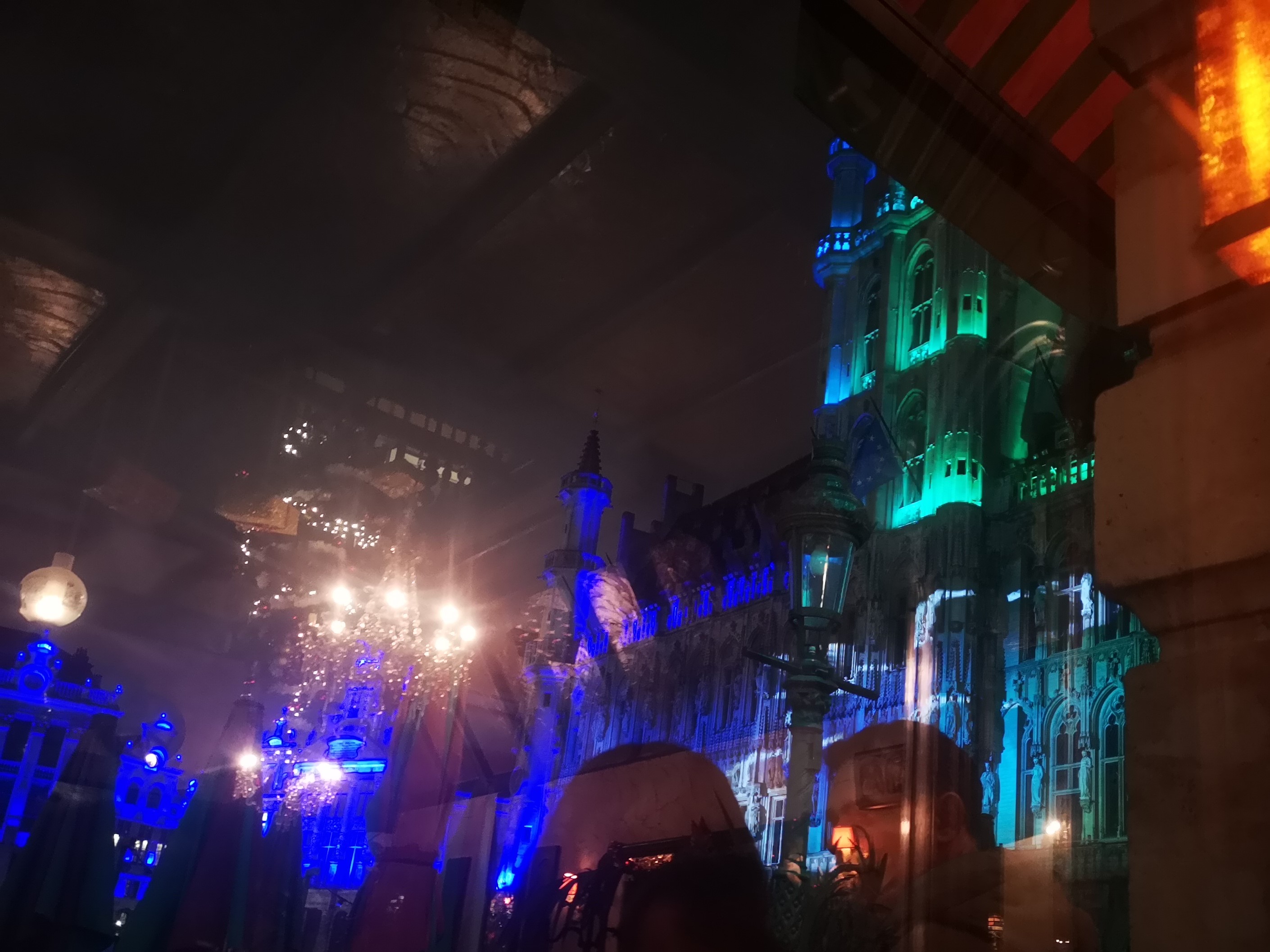 The Grand Place and its buildings lit up in a light show.