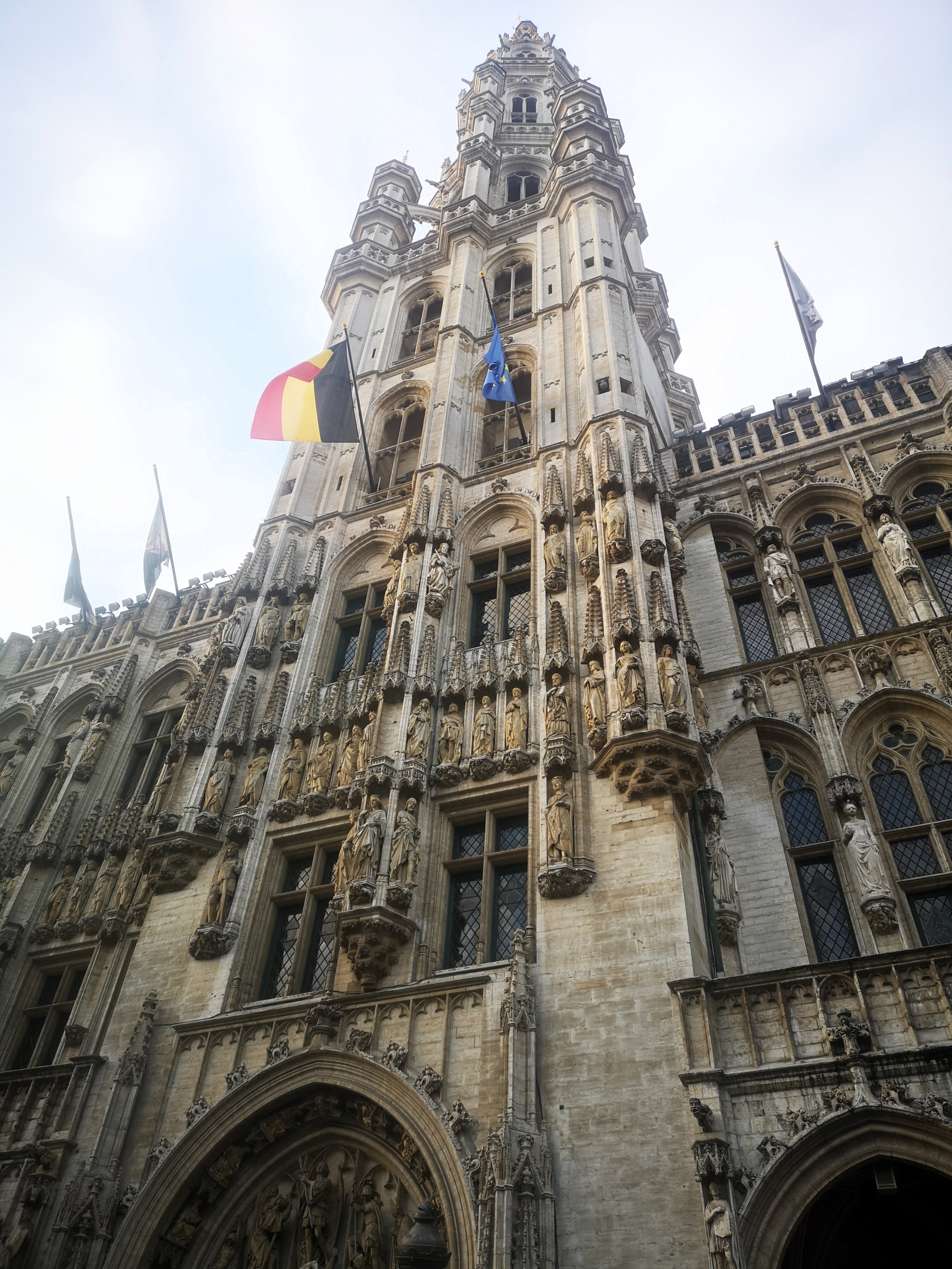 One of Brussels' highlights: The Town Hall from below, complete with a flags flying from the building the Belgian and EU flags in front.