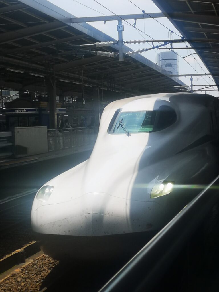 The front of the first bullet train we took on our backpacking adventure. White, smooth and streamlined shape at the front.